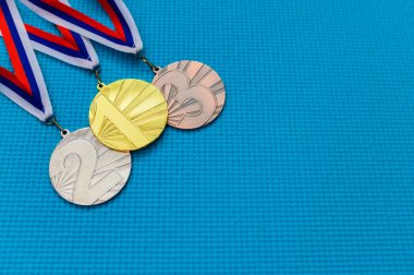 Mavi arka planda altın, gümüş ve bronz madalya. Madalya takvimi konsepti fotoğrafı, boş düzenleme alanı. Tokyo 2020 Yaz Olimpiyatları için orjinal duvar kâğıdı