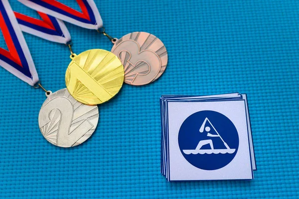 Conjunto de iconos y medallas de Canoa Sprint, medalla de oro y bronce, fondo azul. Fondo de pantalla original para el juego olímpico de verano en Tokio 2020 —  Fotos de Stock