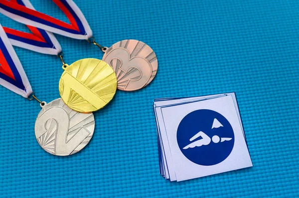 Плаваюча ікона і комплект медалей, золота срібна і бронзова медаль, синє тло. Оригінальний шпалери для літньої олімпійської гри в Токіо 2020 року. — стокове фото