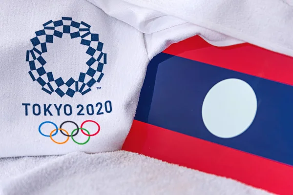 東京、日本、 2月。2020年4月4日:ラオス国旗、東京2020オリンピック夏の公式ロゴ。白地 — ストック写真