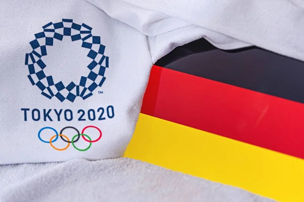โตเกียว ประเทศญี่ปุ่น กุมภาพันธ์ 4, 2020: ธงชาติเยอรมนี, โลโก้อย่างเป็นทางการของการแข่งขันกีฬาโอลิมปิกฤดูร้อนในโตเกียว 2020 สีขาวพื้นหลัง — ภาพถ่ายสต็อก