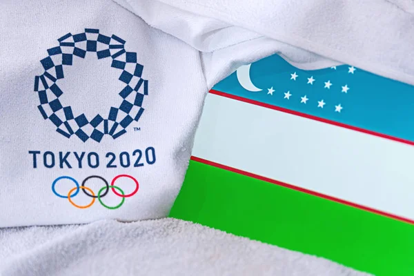 TOKYO, JAPAN, FEBRUARY. 4, 2020: Drapelul național al Uzbekistanului, logo-ul oficial al jocurilor olimpice de vară din Tokyo 2020. Fundal alb — Fotografie, imagine de stoc