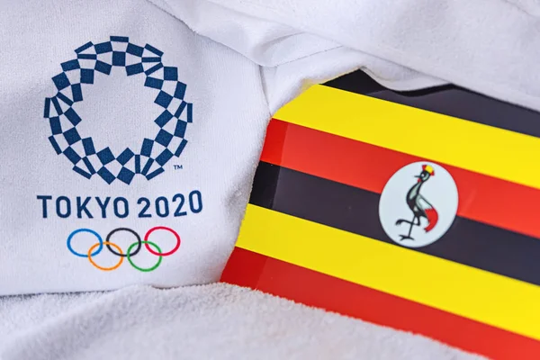 東京、日本、 2月。2020年4月4日:ウガンダ国旗、東京2020オリンピックの公式ロゴ。白地 — ストック写真