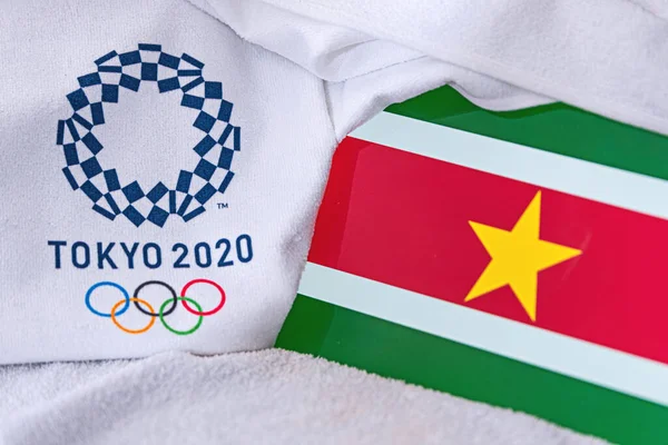 TOKYO, JAPAN, FEBRUARY. 4, 2020: Bendera Suriname Nasional, logo resmi Olimpiade Musim Panas di Tokyo 2020. Latar belakang putih — Stok Foto