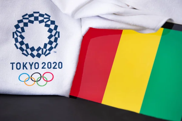 東京、日本、 2月。8 。2020年:ギニア、東京2020オリンピック、国旗、黒の背景 — ストック写真