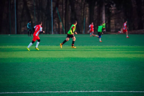 Fotbollsspelare på den gröna planen, suddig bakgrund — Stockfoto