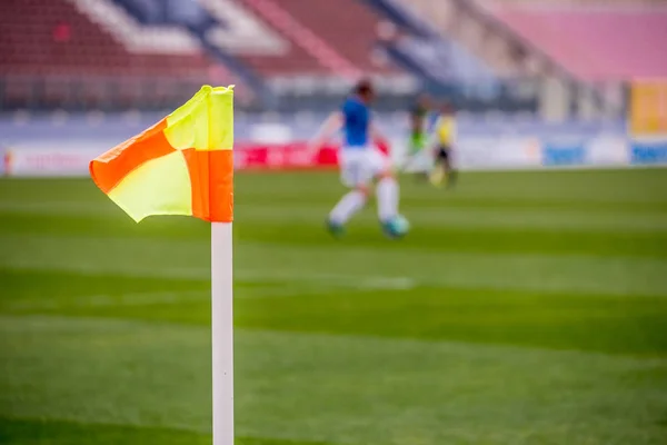 Hörnflagga på fotbollsstadion och fotbollsspelare i bakgrunden, — Stockfoto