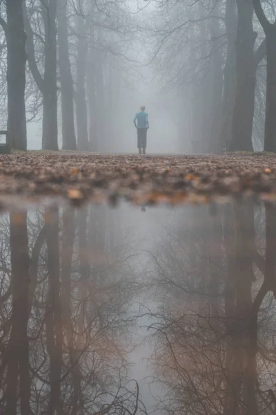Homme courant dans le parc brumeux . — Photo