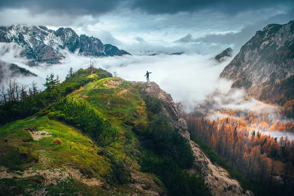 Hombre de pie en la cima de la colina en las montañas mirando a Wond — Foto de Stock