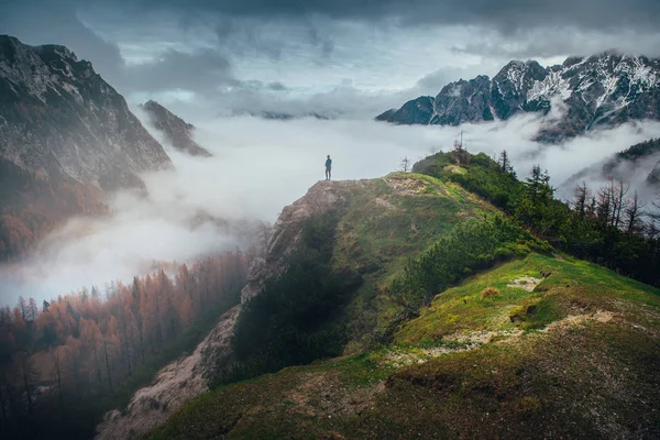 İlham verici bir fotoğraf. Tepenin tepesindeki genç adamın silueti. Arka planda sonbahar doğası. — Stok fotoğraf