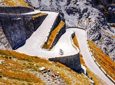 Biker on the road - Cyclist photo. Tour, Italy, Passo dello Stelvio clipart