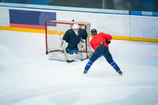 Jugador profesional de hockey sobre hielo en el tren del estadio de hockey sobre hielo junto con el portero. Foto de deporte, editar el espacio, juego de invierno Pyeongchang . —  Fotos de Stock