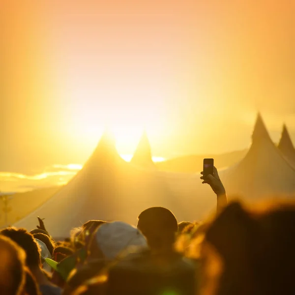 Man hold phone in crowd in summer music festival, summer party, edit space