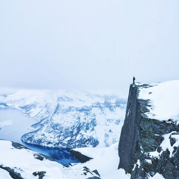 겨울에 바위처럼 하얗게 뒤덮인 바위 위에서 있는 모험적 인 사람 — 스톡 사진