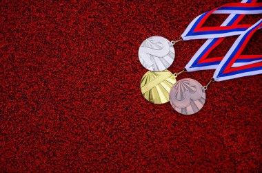 Kırmızı atletizm pistinde madalya, altın gümüş ve bronz madalya, kırmızı duvar kağıdı, madalya töreni konsepti fotoğrafı. Tokyo 2020 Yaz Olimpiyatları için orijinal fotoğraf