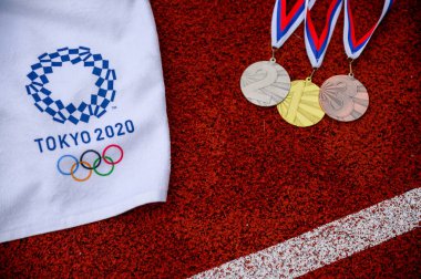 Tokyo, Japonya, 5 Mart. 2020: Olimpiyat Madalyası Töreni, madalya takvimi, fotoğraf çekimi. Altın gümüş ve bronz madalya, Tokyo 2020 logosu olimpiyat oyunu, arka planda kırmızı atletizm pisti