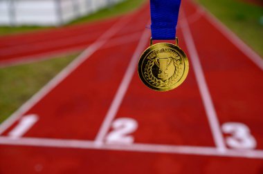 Altın madalyaya, arka planda atletizm koşu parkuruna yazılmış bir şampiyonsun. Tokyo 2020 Yaz Olimpiyatları için orijinal fotoğraf