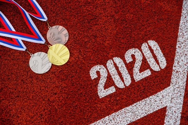 Sport background for Year 2020, gold silver and bronze medal, red athletics track and tittle 2020. Original photo for summer game 2020 in Tokyo. Original photo for summer olympic in Tokyo 2020
