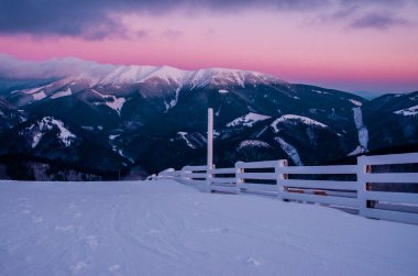 Kış dağlarında pembe gün batımı