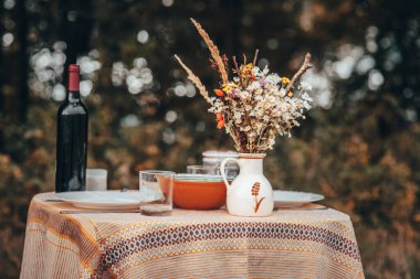 Klasik masa, çiçekler ve doğada öğle yemeği.