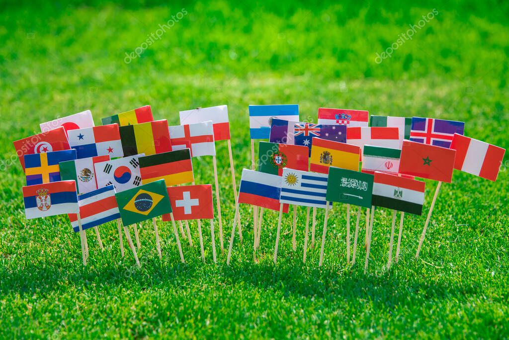 National Flags of all football countries on green grass, Football ball on the stadium.