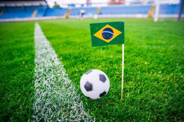 Brezilya ulusal bayrağı ve futbol topu yeşil çimlerin üzerinde. Hayranlar, fotoğrafı destekleyin, alanı düzenleyin