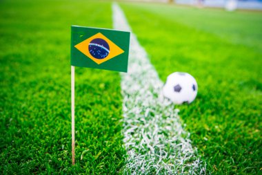 Brezilya ulusal bayrağı ve futbol topu yeşil çimlerin üzerinde. Hayranlar, fotoğrafı destekleyin, alanı düzenleyin