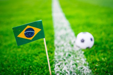 Brezilya ulusal bayrağı ve futbol topu yeşil çimlerin üzerinde. Hayranlar, fotoğrafı destekleyin, alanı düzenleyin