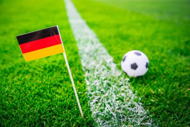 Almanya ulusal bayrağı ve futbol topu yeşil çimlerin üzerinde. Hayranlar, fotoğrafı destekleyin, alanı düzenleyin