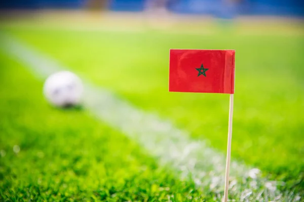 Morocco national Flag and football ball on green grass. Fans, support photo, edit space