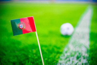 Portekiz ulusal bayrağı ve yeşil çimlerin üzerinde futbol topu. Hayranlar, fotoğrafı destekleyin, alanı düzenleyin