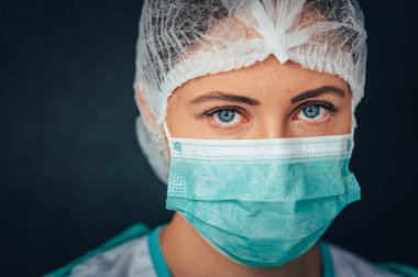 Bulaşıcı hastalıklara karşı koruma, koronavirüs. Portre fotoğrafı. Hastane koğuşunda koruyucu yüz maskesi takan kadın doktor.