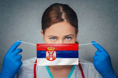 Sırbistan 'daki Coronavirus Kadın Doktor Portresi, Face' i Sırbistan Ulusal Bayrağı altında ameliyat maskesiyle koruyor. Sırbistan 'da Hastalık, Virüs Covid-19, konsept fotoğraf