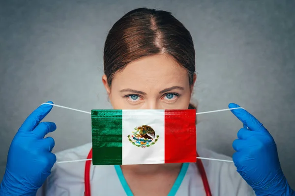 Coronavirus in Mexico Female Doctor Portrait hold protect Face surgical medical mask with Mexico National Flag. Illness, Virus Covid-19 in Mexico, concept photo