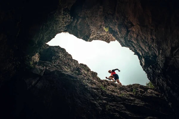 跑步者的轮廓 人在岩石山中奔跑 不寻常的径赛跑动照片 — 图库照片