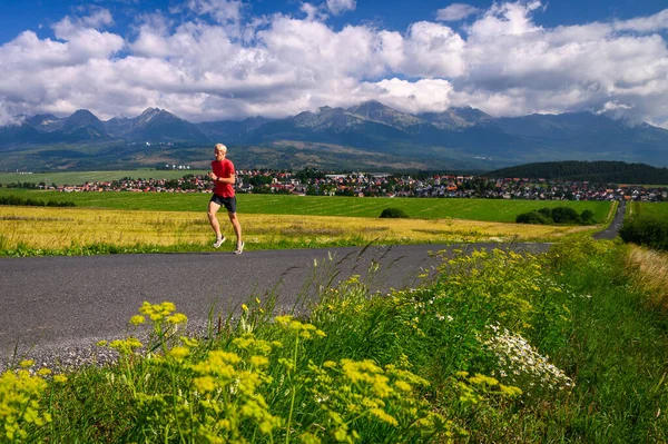 Summer running training. Long distance runner train in summer landscape