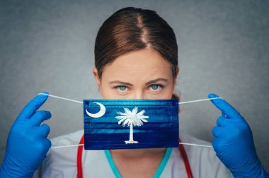 Güney Carolina 'da Coronavirus, Kadın Doktor Portresi, Güney Carolina bayrağıyla Face cerrahi maskesini koruyun. Hastalık, Virüs Covid-19 Güney Carolina