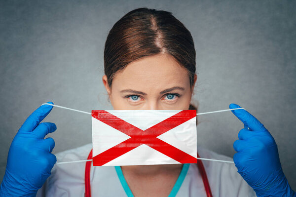 Coronavirus in U.S. State Alabama, Female Doctor Portrait, protect Face surgical medical mask with Alabama Flag. Illness, Virus Covid-19 in Alabama