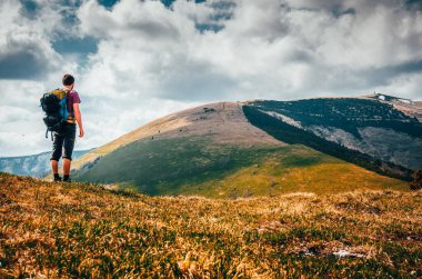 Karpatya dağlarındaki yeşil çimlerin üzerinde çıplak ayakla yürüyen bir turist. Aktif sağlık, turizm konsepti fotoğrafı