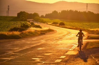 Bisikletli adam ve yaz günbatımı
