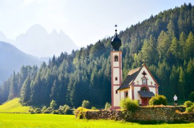 Dolomitlerin eteklerinde bir kilise. Funes Valley, Dolomitler, İtalya. Sonbahar güneşi altında Aziz John Kilisesi