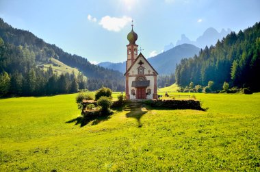 Dolomitlerin eteklerinde bir kilise. Funes Valley, Dolomitler, İtalya. Sonbahar güneşi altında Aziz John Kilisesi