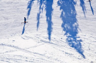Güneşli kış günlerinde snowboard yapan adam dağlarda aktif.