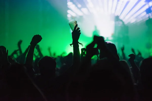 Hands silhouette in the air in summer music festival - colorful background