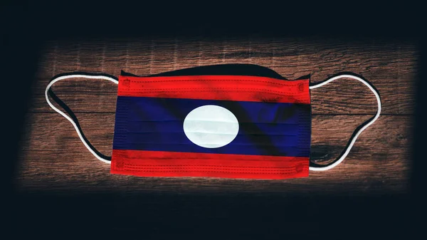 Laos National Flag Medical Surgical Protection Mask Black Wooden Background — Stock Photo, Image