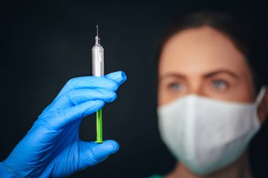 Coronavirus Covid-19 Koruma ve Aşı. Grip, koronavirüs, ebola, tüberküloz aşısı üzerinde çalışan kadın tıp bilimci. Koruyucu giysi ve maske şırınga ve aşı taşıyor..