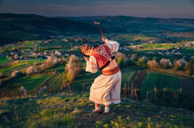 Geleneksel Slovak halk elbisesi giymiş bir adam bahar doğasında dans ediyor. Hrinova Slovakya
