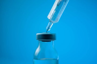 Beyaz arka planda tıbbi ampuller ve şırınga