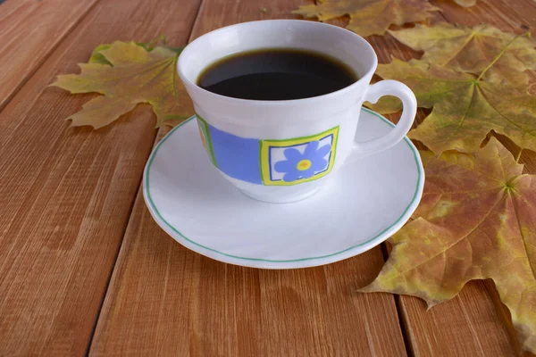 Kaffeetasse Auf Hellbraunem Holzhintergrund Neben Gelben Blättern — Stockfoto