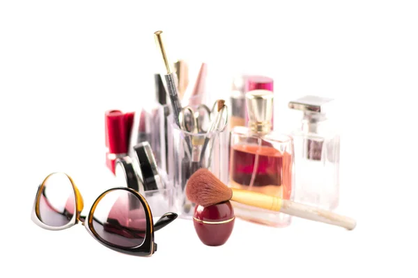 Cosmetic kit, cosmetics items, brush and glasses in the foreground